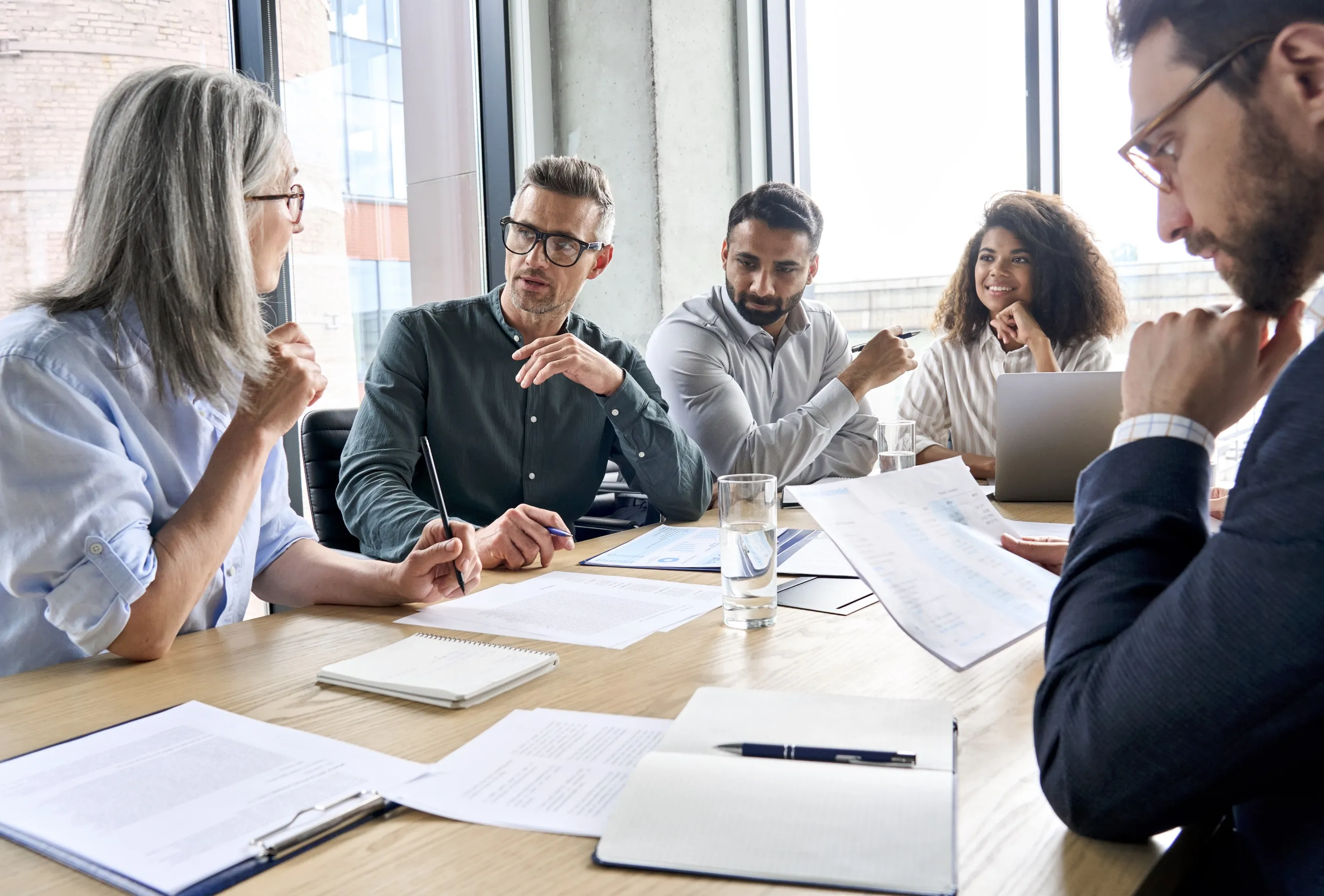 Group of diverse professionals discussing AI governance in a modern conference room.